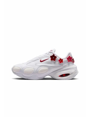 Chaussure de sport blanche avec un swoosh Nike rouge et des embellissements floraux rouges le long de la cheville et du talon, vue de profil.