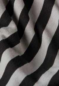 Tkanina w czarno-szare paski, z naprzemiennymi poziomymi pasami o różnych szerokościach i miękkim, teksturowanym wykończeniem.