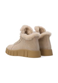 Beige Wildleder Stiefeletten mit flauschigem Futter, schnürbarem Vorderteil und einer dicken Gummisohle mit geriffeltem Muster.