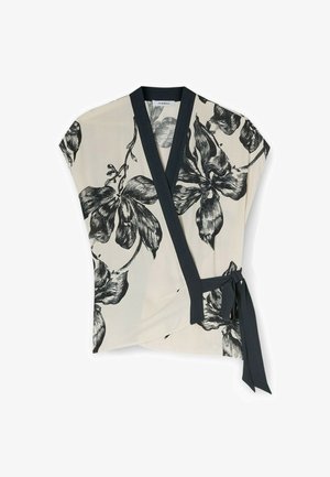 Halenka s krémovou látkou a černým květinovým vzorem, která má tmavě modrý lem kolem véčkového výstřihu a boční zavazování.