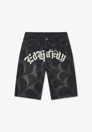 Schwarze Jeansshorts mit grauem Spinnennetzmuster und weißem gotischem Schriftzug „Ed Hardy“ vorne.