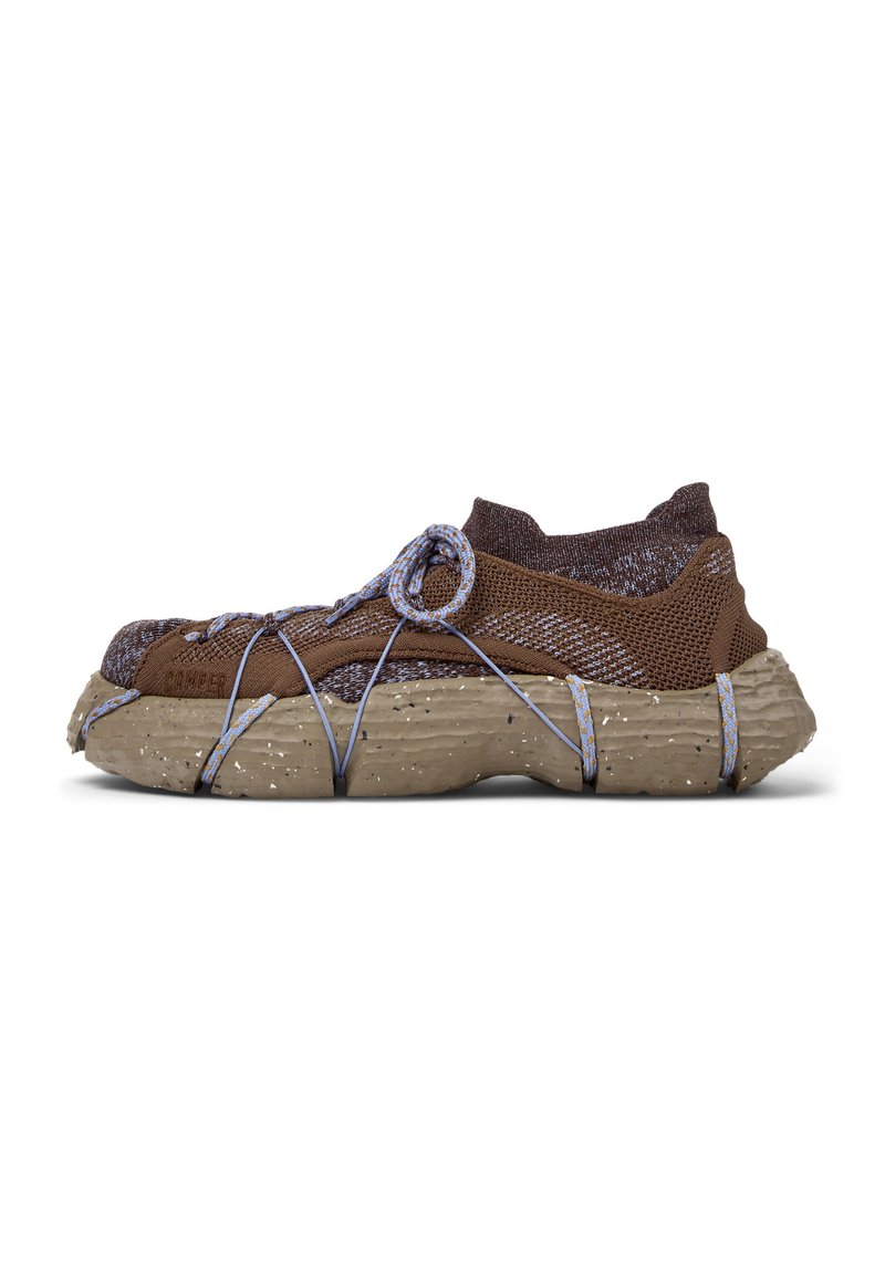 Brown mesh sneaker with textured rubber sole, blue accents, and crisscross elastic laces. Features a rounded toe and a slip-on design.