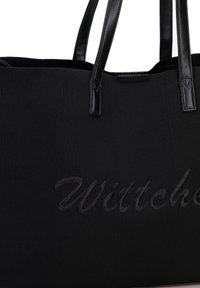 Czarna torba na ramię wykonana z teksturowanej tkaniny, z czarnymi skórzanymi uchwytami i wytłoczonym logo "Wittchen" z przodu.