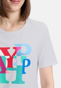 Grijs T-shirt met korte mouwen, versierd met kleurrijke letters in rood, blauw, groen en roze met een textuur en glanzende accent.