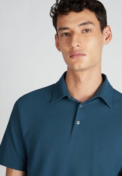 Polo color teal realizzato in tessuto liscio, con colletto, maniche corte e patta con due bottoni, senza motivi o dettagli.