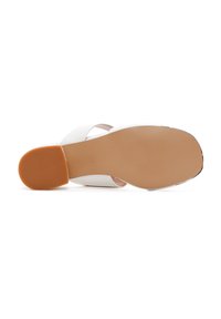 Nu-pieds blancs avec une tige synthétique lisse et une semelle en caoutchouc beige. Présentent un design de large sangle et un petit talon bloc.