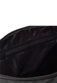 Eine offene schwarze Tasche, die ihr Inneres zeigt, mit einer glatten Innenausstattung und einer Reißverschlusstasche an der Seite. Das Innere ist dunkel und geräumig.