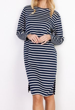 Marineblå kjole med horisontale hvide striber, lange ærmer, rund halsudskæring og sideslids for bevægelsesfrihed. Glat stof tekstur.