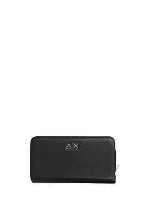 Billetera rectangular negra con cremallera alrededor, con un pequeño triángulo plateado y un logo de cruz en la parte frontal.
