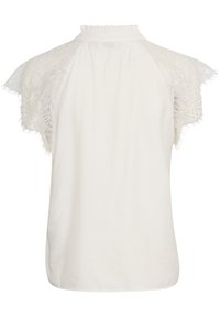 Haut blanc avec de courtes manches en dentelle, présentant un col montant froncé et des bords délicatement effilochés. La dentelle texturée ajoute du détail au design.