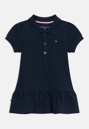 Tumesinist värvi lühikeste varrukatega polo-tüüpi kleit krae, kolme nööbi, väikese rinnamärgiga ja volsitud alumise äärega väikelastele tüdrukutele.