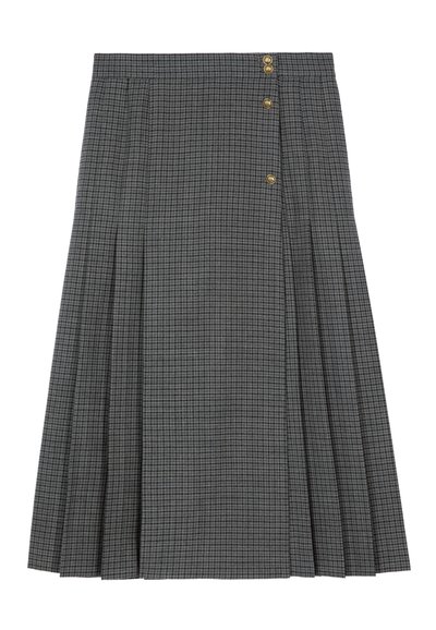Jupe grise à carreaux, longueur genoux, en tissu avec un design plissé. Dispose de trois boutons dorés à l'avant pour la fermeture.