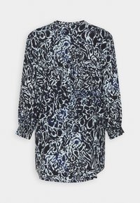 Blusa de manga larga en blanco y negro con patrón abstracto, con ligeros fruncidos en los puños y un escote redondeado, vista desde la parte posterior.