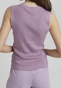 Haut sans manches en tricot côtelé de couleur lavande claire, avec un col rond et une silhouette ajustée. Texture douce avec une finition lisse.
