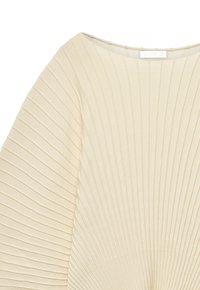 Pull en tricot côtelé de couleur crème avec encolure bateau et larges manches présentant des motifs côtelés horizontaux et verticaux.