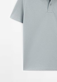 Lys grå polo skjorte med klassisk krave, korte ærmer, to-knap lukning og en glat bomuldsstruktur.