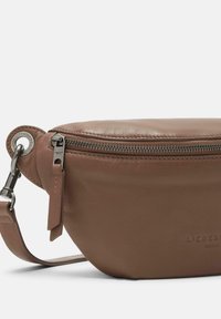 Borsa a tracolla in pelle marrone con forma arrotondata, chiusura con zip, accessori in argento e logo in rilievo sul lato. Texture liscia, design minimal.