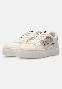 Witte sneaker met een getextureerd beige zijpaneel, zilveren accenten en een dikke zool. Voorzien van vetersluiting en geperforeerde tenen voor ventilatie.