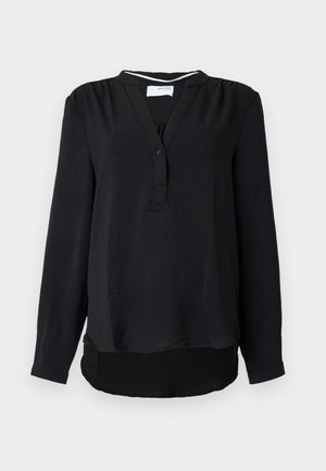 Črna bluza z dolgimi rokavi in sproščenim krojem, gumbom na zadrgo in diskretno teksturirano tkanino, z ovalnim robom.
