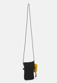 Sac bandoulière en tissu noir avec une longue sangle réglable, doté d'une pochette zippée jaune attachée sur le côté. Design minimaliste, forme rectangulaire.