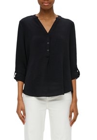 Chemise noire à manches longues avec un col en V et trois boutons à l'avant, avec un tissu texturé et des manches retroussées.