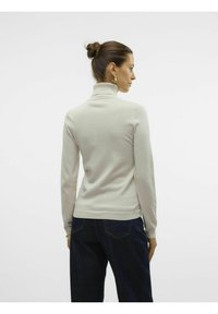 Maglione a collo alto di un beige chiaro, realizzato in un morbido tessuto a maglia, design aderente con maniche lunghe, polsini a coste e colletto aderente.