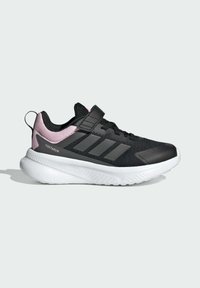 Black athletic sneaker with pink accents, featuring a textured mesh upper, hook-and-loop strap, and a white rubber sole with patterned tread.