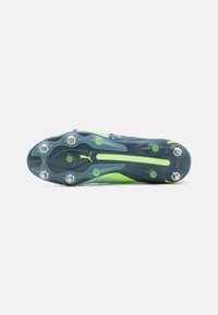 Botín de fútbol que presenta un diseño en azul y verde, material texturizado y seis clavos metálicos para una mejor tracción en la suela.