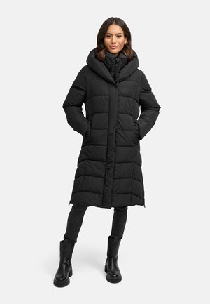 Black, padded long coat with a detachable hood, diagonal stitching, and side pockets, worn over black fitted pants and boots.