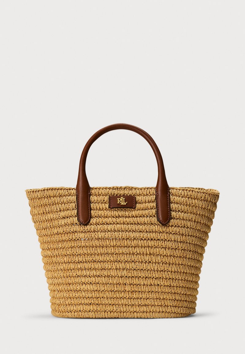 Sac cabas en paille tissée avec deux poignées en cuir marron et une petite pièce en cuir avec le logo doré RRL au centre devant.
