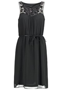 Robe noire sans manches avec un corsage en dentelle et paillettes, une taille élastique et un détail à nouer. Tissu doux et texturé avec un design fluide.