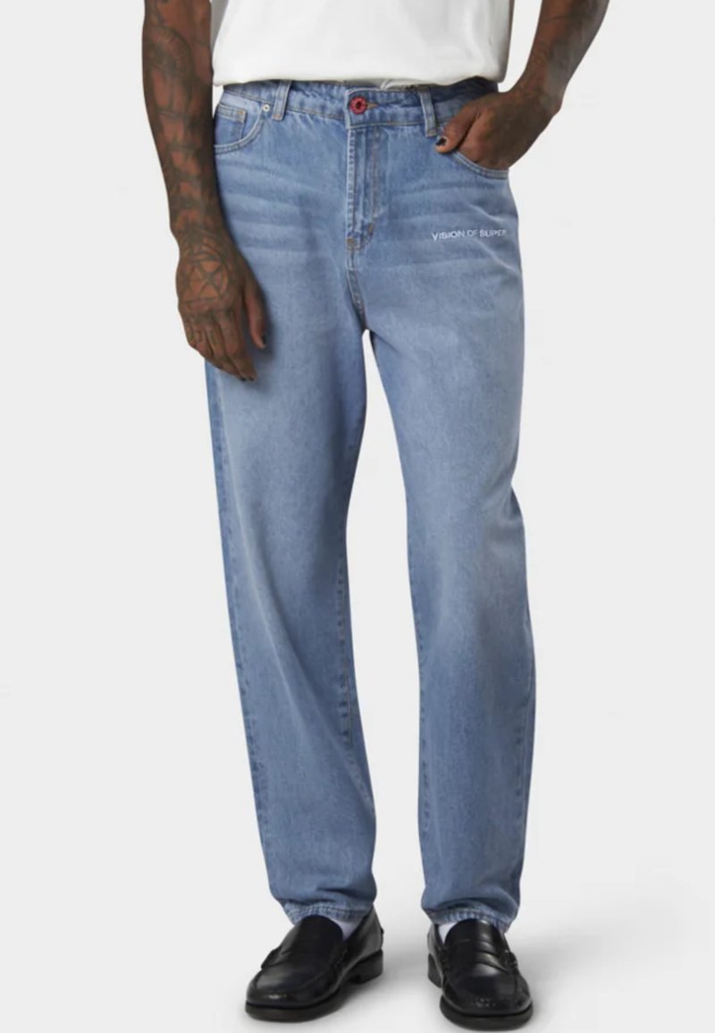 Jeans in denim azzurro chiaro con una vestibilità rilassata, dotati di un bottone rosso, testo ricamato "VISION OF SUPER" sul davanti e leggere scoloriture.