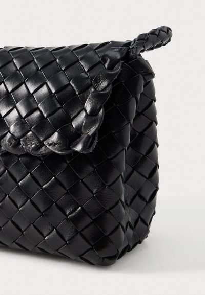 Μαύρη δερμάτινη τσάντα χειρός με υφαντή υφή, στρογγυλεστό καπάκι και πλεγμένο λουράκι. Συμπαγές σχήμα με λείο φινίρισμα και γυαλιστερή όψη.