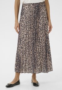 Maxirock aus leichtem Material, mit einem pinken Grundton und schwarzem Leopardenmuster. Faltenwurf und gezackter Saum, getragen mit schwarzen Ballerinas.