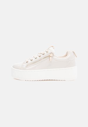 Helle beige Lackledersneakers mit einer weißen Plateausohle, Schnürung an der Vorderseite und seitlichem Reißverschluss. Glatte Textur und minimalistisches Design.