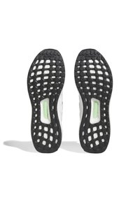 Sneakersulor med en svart gummibas med texturerat grepp, genomskinliga utskärningar och en grön accent i mitten.