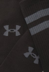 Schwarze Socken mit strukturiertem Strick, grauem Logo und zwei grauen Streifen, die horizontal nahe der Oberseite verlaufen.