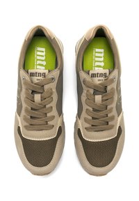Zapatillas beige y marrón con detalles de malla, ante texturizado, cordones redondos y una plantilla verde con marca. Diseñadas para la comodidad y el estilo.