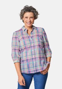 Camicia check a maniche lunghe con colori blu chiaro, rosa e giallo. Presenta maniche a tre quarti e un orlo curvo. Tessuto leggero.