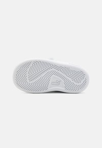 Semelle de chaussure de sport blanche en caoutchouc texturé et non marquant, avec un motif en zigzag et un logo au talon. Design arrondi et plat.