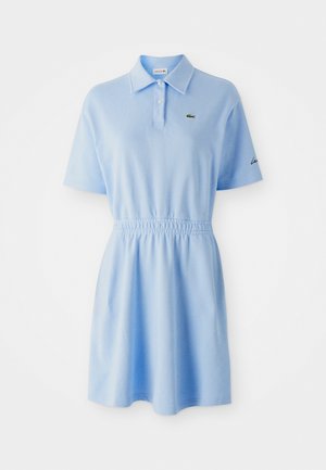 Vestido polo de manga corta azul claro con cuello abotonado, cintura elástica y pequeño logotipo de cocodrilo verde en el pecho izquierdo.