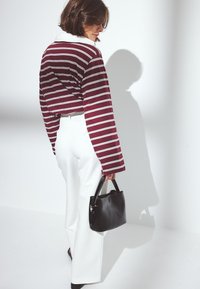 Maroonowe i białe paski, długi rękaw, biała szeroka nogawka, czarna torebka. Miękka tkanina o luźnym kroju z detalem kołnierza.