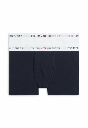 Granatowe bokserki z białym paskiem w talii, na którym wielokrotnie powtarzają się logo Tommy Hilfiger i emblemat flagi.