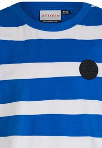 Niebiesko-biała koszulka w paski z okrągłym dekoltem i czarną okrągłą naszywką z logo po lewej stronie. Bawełnowy materiał o miękkiej teksturze.