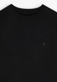 Sudadera negra con cuello redondo, con mangas raglán y un pequeño logo de calavera en el lado izquierdo. Textura suave, tejido ligero.