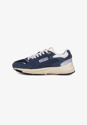 Sneaker blu navy con tomaia in suede e mesh, lacci crema, intersuola beige e dettaglio argentato sul tallone. Logo posizionato sul lato.