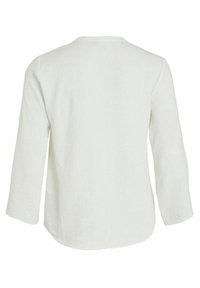 Chemise blanche à manches longues avec un col rond, texture douce et épaules tombantes ; elle pr ésente un ourlet incurvé et une coupe décontractée.