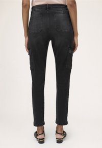 Svarta denim cargo byxor med hög midja, avsmalnande ben, två sidofickor och två bakfickor, med en blekt textur och synliga sömmar.