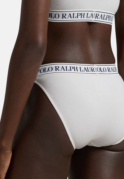 Weißer Baumwollslip mit weicher, elastischer Textur. Verfügt über einen marineblauen Bündchenbund mit wiederholtem "POLO RALPH LAUREN"-Schriftzug.