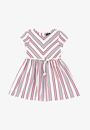 Robe blanche à manches courtes avec des rayures diagonales et verticales rouges, bleues et jaunes, et une ceinture en corde blanche nouée à la taille.